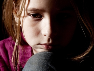 Sad child on black background. Portrait depression girl